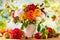 Autumn still life with garden flowers. Beautiful autumnal bouquet in vase, apples and berries on wooden table. Colorful dahlia and