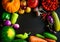 Autumn still life with pumpkin, watermelon, and a variety of colorful vegetables on black wooden background. Happy Thanksgiving