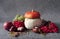 Autumn still life. Pumpkins, apples, chestnut fruits, coriander seeds, viburnum branches, grapes are located on a gray background.