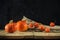 Autumn still life. pumpkins with physalis on a rough burlap and boards on a dark concrete background