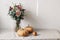 Autumn still life scene. Orange pumkins, pear fruit on linen table cloth in sunlight. Floral bouquet of dahlia flowers