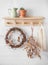 Autumn still life - wooden shelf with a vine wreath, ceramic jug, cactus, dried flowers, fabric bag in a bright room. Cozy eco