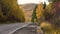 Autumn sunny day. Mountain landscape. Yellow leaves on the trees. Empty suburban highway