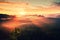 Autumn sunrise panorama in a beautiful mountain within inversion. Peaks of hills increased from heavy fogg