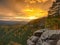 Autumn sunset view over sandstone rocks to fall colorful valley of Bohemian Switzerland. Sandstone peaks in forest.