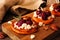 Autumn sweet potato crostini appetizers with cheese, cranberries and pecans close up