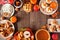 Autumn table scene frame of pies, appetizers and desserts. Top view over a wood background with copy space.