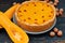 Autumn tart with goji berry decorated with hazelnuts on the black rustic wooden background. Traditional dessert for Thanksgiving