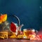 Autumn teatime composition on dark background with colored leaves and chocolate cookies, sun light beam on the cup behind the