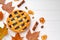 Autumn thankgiving pie on white wooden board decorated with dry leaves and cinnamon sticks