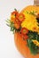 Autumn or Thanksgiving floral arrangement in pumpkin on a white background. Vertical image with copy space.