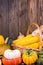 Autumn Thanksgiving motive with a basket full with corn cobs and different colorful pumpkins on an old rustic wooden background