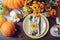 Autumn traditional seasonal table setting at home with pumpkins, candles and flowers