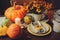 Autumn traditional seasonal table setting at home with pumpkins, candles and flowers