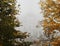 Autumn trees frame with old white manor castle in fog nice fall foliage