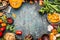 Autumn vegetables cooking preparation . Pumpkin, tomatoes, root vegetables and mushrooms ingredients on dark rustic background for