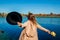 Autumn vibes. Young woman relaxing by river and having fun. Girl raising arms welcoming fall