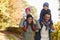 Autumn Walk With Parents Carrying Children On Shoulders