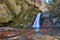 Autumn waterfall and creek woods with yellow trees foliage and r