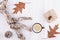 Autumn or winter composition with a cup of coffee, autumn dry leaves, driftwood on a rustic whitewashed wooden