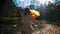 Autumn woman happy throwing fall leaves having fun laughing, playing and running in beautiful colorful forest foliage