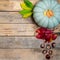 Autumn wooden background with yellow-red and green leaves, pumpkin and chestnut. Composition on a natural table made of