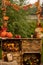 Autumn wooden stand with decoration, apples, leaves, mug, hedgehock in the park