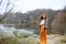 Autumn young woman with flower wreath in fur coat outdoors near the pond