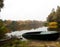 Autumnal landscape with tranquil river, old boats,bank,grass,trees,forest