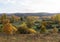 Autumnal meadows and groves landscape with low hills in the background