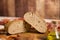Autumnal rustic food: a whole loaf cut in half on an old wooden cutting board, ampoule of extra virgin olive oil and red and