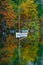 Autumnal scenic view of boats on the Bohinj lake surrounded by colorful forest. Slovenia, Europe