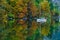 Autumnal scenic view of boats on the Bohinj lake surrounded by colorful forest. Slovenia, Europe