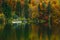 Autumnal scenic view of boats on the Bohinj lake surrounded by colorful forest. Slovenia, Europe