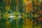 Autumnal scenic view of boats on the Bohinj lake surrounded by colorful forest. Slovenia, Europe, Triglav National Park