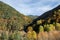 An autumnal valley with orange, yellow and green trees