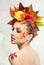 Autumnal woman. Beautiful creative makeup and hair style in fall concept studio shot. Beauty fashion model girl with fall makeup