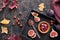 Autumntime background. Fresh halved fig fruits on black wooden tray. Magenta towel and dry red Autumn leaves on dark