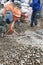 auxiliary worker develops a cement mortar in a concrete mixer at the construction of a country house