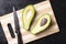 Avacado and seed on kitchen board, black wooden table, top view and copy space