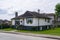 Average family house with green lawn on cloudy day in Canada