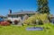 Average family house with nicely decorated front yard on blue sky background. Main entrance of residential house with stairway