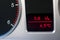 Average fuel consumption and a thermometer in used family car dashboard .