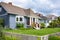 Average residential house with lush front yard lawn on land terrace