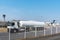 Aviation fuel tanker unloading at an airport facility, with the control tower and an airplane in the background