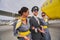 Aviator and two joyous flight attendants by a landed aircraft