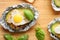 Avocado baked with egg in foil on wooden table