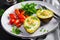 Avocado baked with egg and fresh salad. Vegetarian dish.