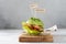 Avocado burger with salted salmon and fresh vegetables, sesame seeds and microgreen. Healthy raw food, keto dieting recipe.