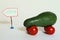 Avocado car with tomato wheels and health arrow